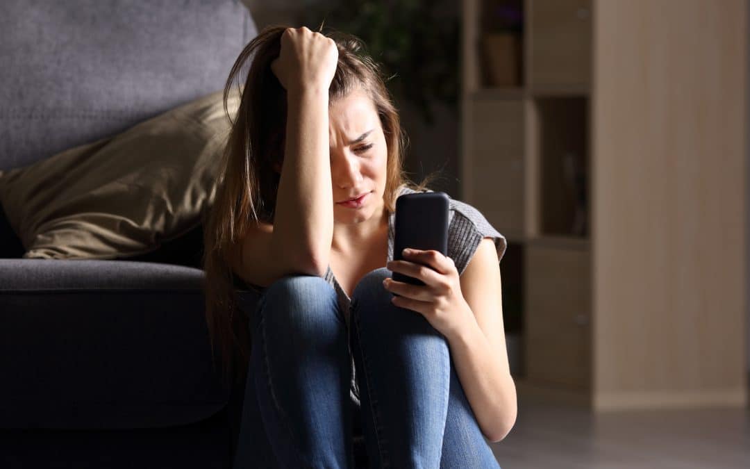 Woman distraught with phone in hand
